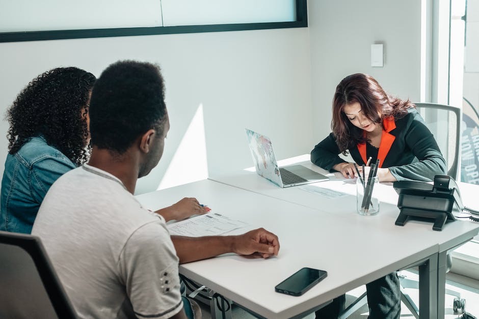 A couple sitting at a desk with a collaborative lawyer in Fort Lauderdale, who is writing on a pad, depicting a professional legal consultation